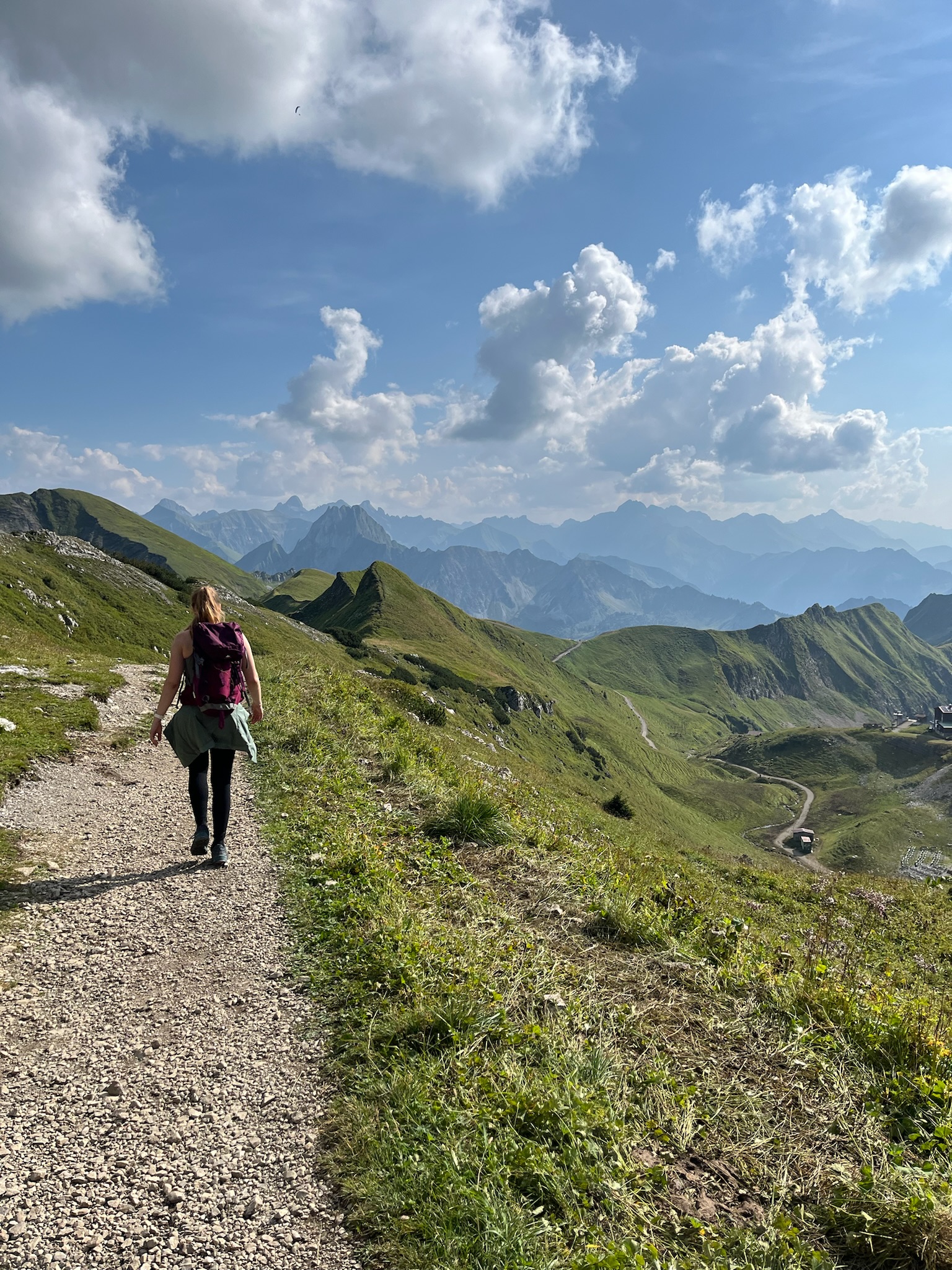 Wanderin auf einem Bergpfad mit Alpenpanorama